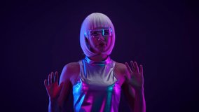 Stylish futuristic woman with white hair, holographic smart glasses, and shiny silver outfit interacting with a virtual interface. She is illuminated by neon pink and blue light in a dark background. - Powered by Shutterstock - Get 15% off with code: PIKWIZARD15