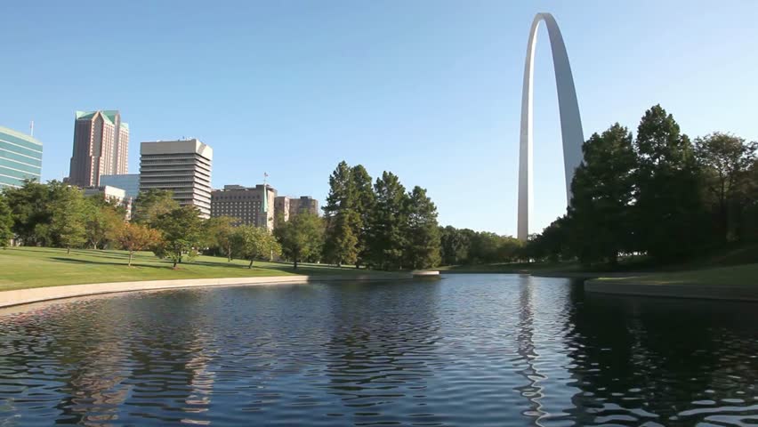 The gateway arch in st louis missouri reflecting in a pond on a sunny day