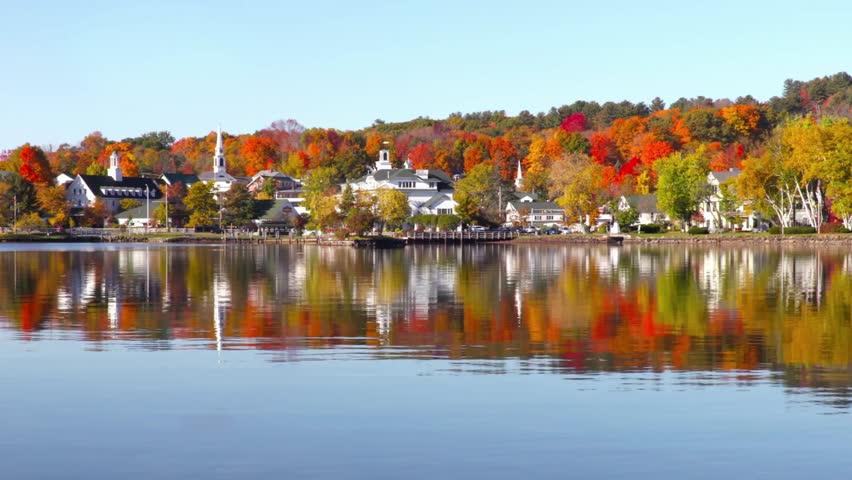 Beautiful fall foliage reflecting on the lake in stowe, vermont on a sunny day