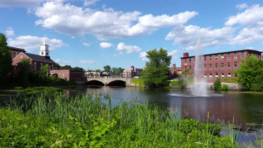 A beautiful view of a pond with a fountain in manchester, new hampshire