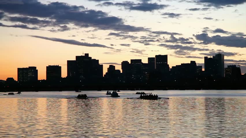 Sunset over the charles river in boston, massachusetts with boats on the water