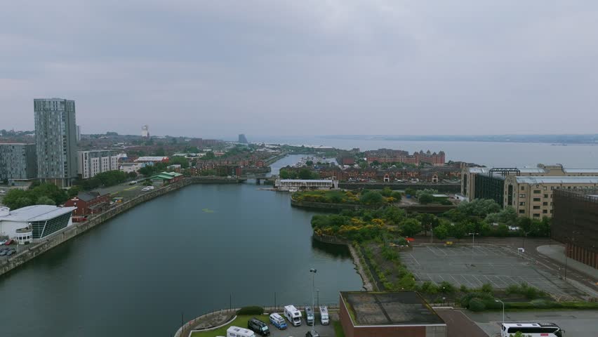 Historic Liverpool docks on overcast day, Coburg Dock and River Mersey in background, England, UK. Aerial forward