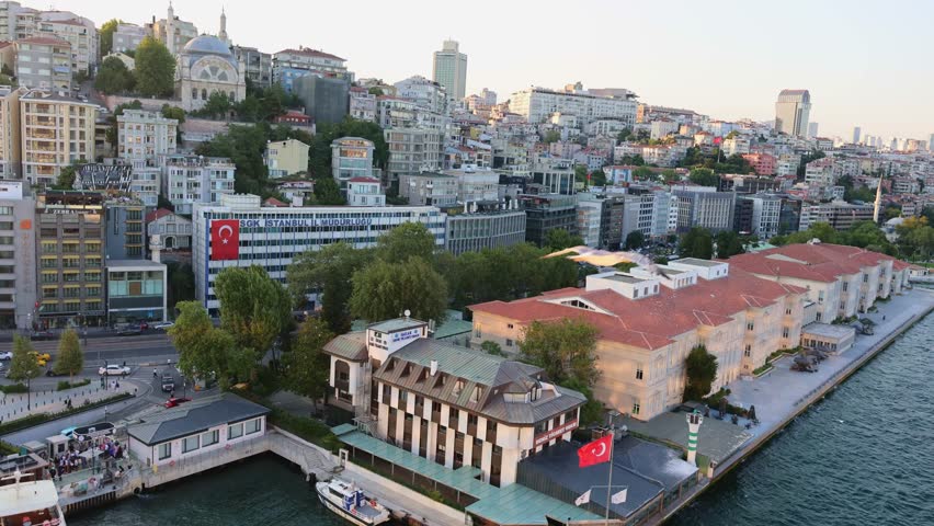 Istanbul, Turkey - July 18, 2025: Panoramic view of Istanbul in evening. View of passenger port, pedestrian embankment, residential buildings and mosques, Turkey. handheld. 4k footage