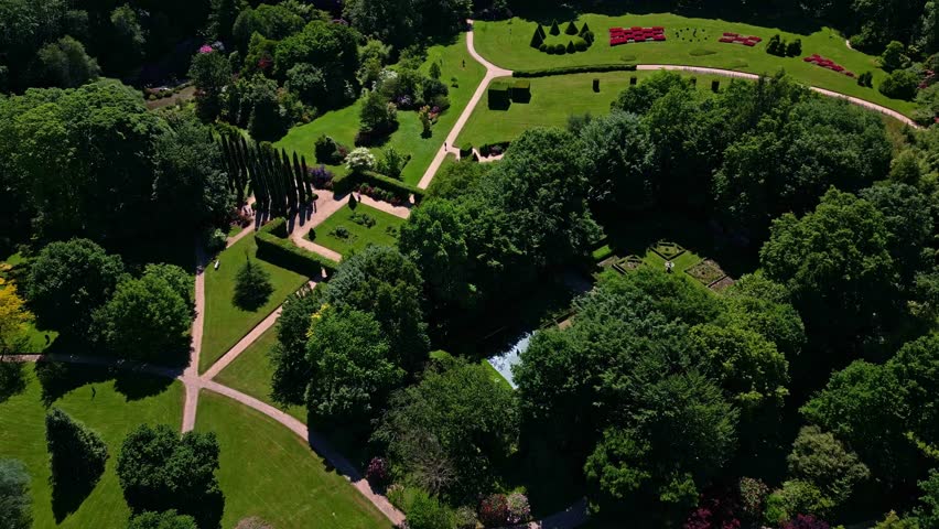 Parc de Haute Bretagne, lawns, ponds, diverse trees, Brittany in France. Aerial drone ascending