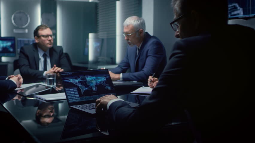 Executives Gather Around a Conference Table, Analyzing Global Data on Laptops and Discussing Strategic Objectives. Participants Take Notes, Review Charts, and Collaborate on Corporation Meeting Topic