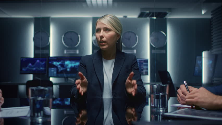 Female Corporate Executive Leads a Discussion With Colleagues in Conference Room, Explore Digital Charts and Global Data on Monitors While Team Members Take Notes and Analyze Financial - Powered by Shutterstock - Get 15% off with code: PIKWIZARD15