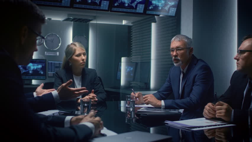 Executives Gather Around a Conference Table, Reviewing Printed Reports While Digital World Maps and Data Charts Are Displayed on Monitors, Analysis of Financial Data, Teamwork of Business Leaders - Powered by Shutterstock - Get 15% off with code: PIKWIZARD15