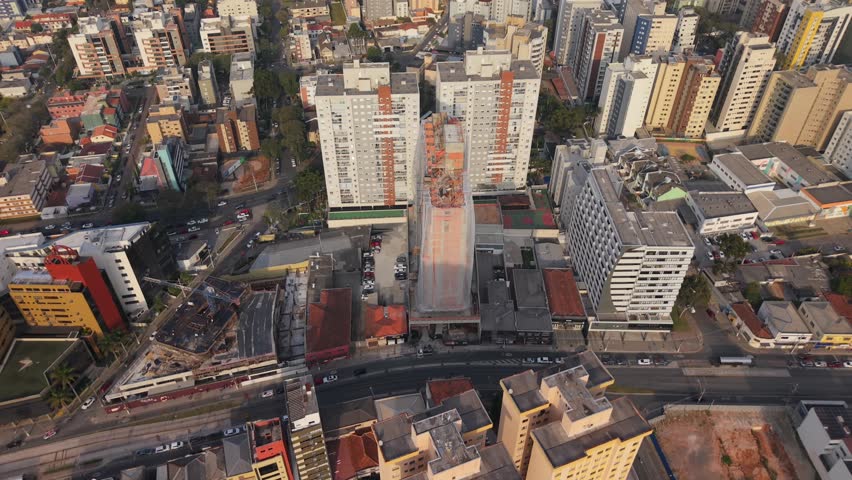 Aerial view of a high-rise building under construction surrounded by residential towers in Curitiba.