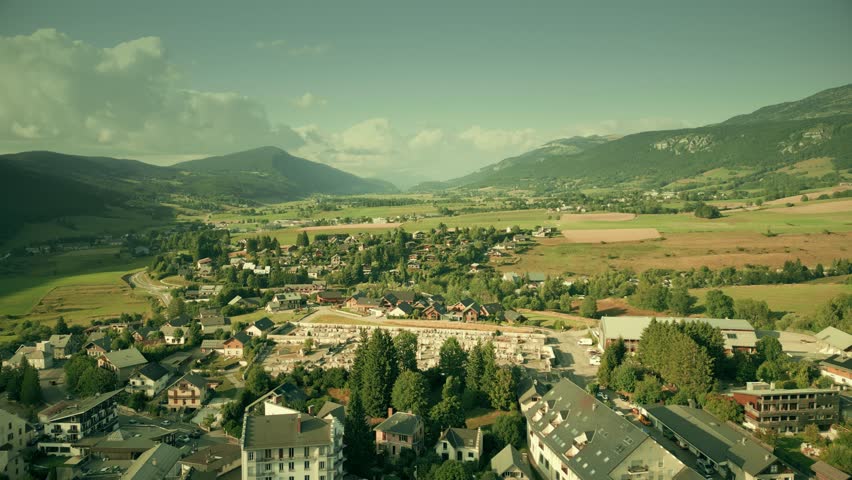 Scenic aerial view of Villard-de-Lans surrounded by Vercors mountains and green fields, heading north