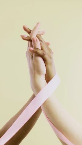 Female hands gently holding a pink ribbon, symbolizing breast cancer awareness and support. High-resolution image with soft lighting and a clean background, perfect for health campaigns and awareness 