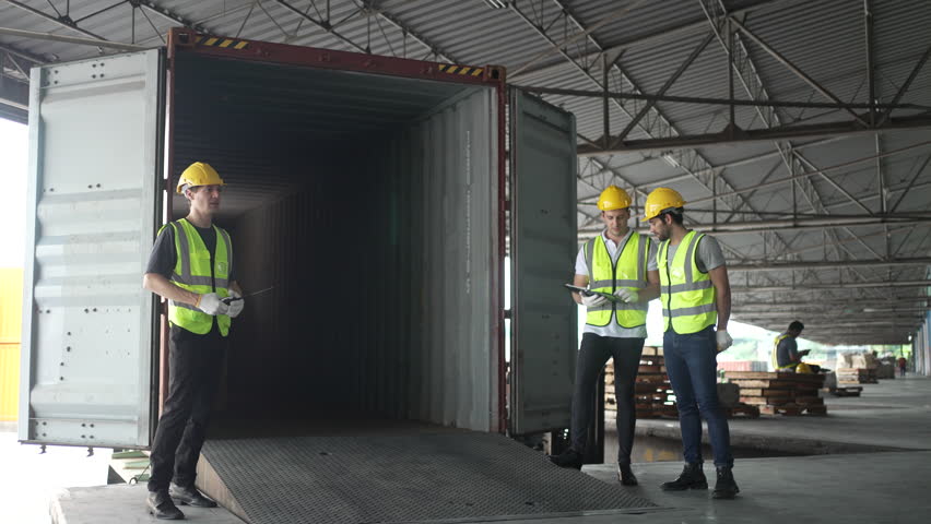 Blue collar workers are working at warehouse. Logistics, transportation.