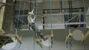 Young boy carefully crossing hanging wooden bridge in indoor climbing center. Creative - Powered by Shutterstock - Get 15% off with code: PIKWIZARD15