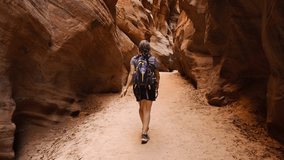 Female Hiker and The Vertical Sandstone Walls of Buckskin Gulch, Vermillion Cliffs National Monument, Utah, USA - Powered by Shutterstock - Get 15% off with code: PIKWIZARD15