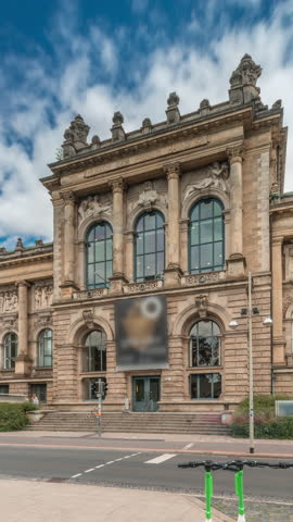 Hyperlapse of Hanover's Lower Saxony State Museum with passing traffic and people in front of its historic facade. Cloudy sky frames cultural landmark in the heart of Germany s Niedersachsen timelapse