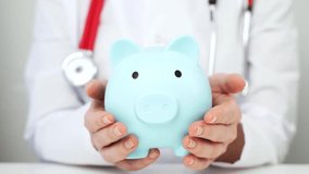 A Doctor Woman Holding a Piggy Bank in Her Hands. Concept of additional medical insurance. Lca - Powered by Shutterstock - Get 15% off with code: PIKWIZARD15