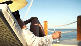 Woman with cocktail on sun lounger by the sea at sunset - Powered by Shutterstock - Get 15% off with code: PIKWIZARD15