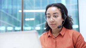 African american female corporate operator in headset working in customer support service on helpline telesale talking using laptop in business office. Agent of call center advises client. Close up - Powered by Shutterstock - Get 15% off with code: PIKWIZARD15