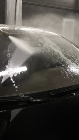 Washing a car windshield at a car wash. Car wash concept.