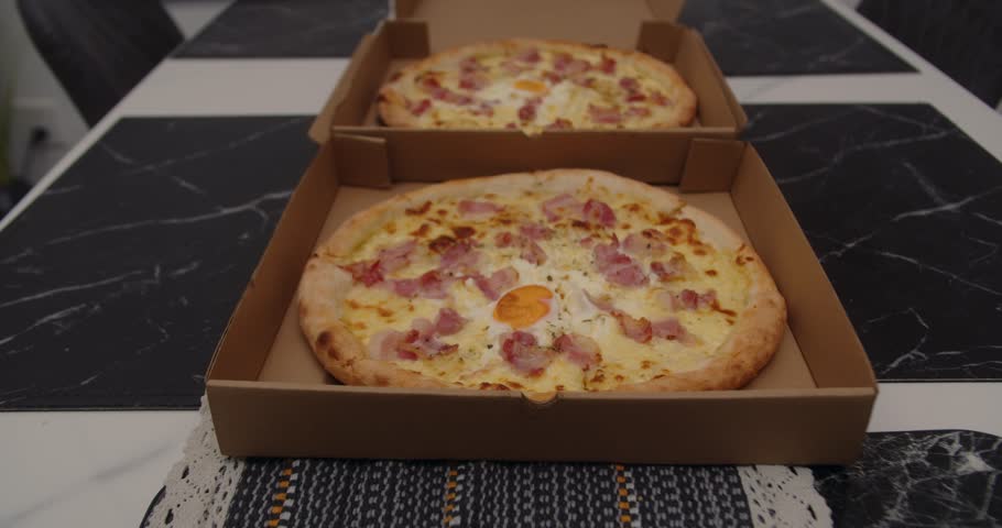 Tasty Italian pizza in an open box, ready to serve. Ideal party food for friends. Open pizza box with delicious Italian pizza. Food service for parties, perfect for sharing with friends and enjoying