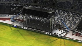 Music concert stage set up buildup construction. stadium football pitch being prepared to host a music concert. sports stadium as technicians set up the stage for the live music event. - Powered by Shutterstock - Get 15% off with code: PIKWIZARD15