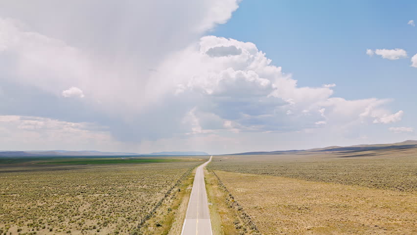 Aerial view of highway leading through the landscape with Wyoming on one side and Utah on the other.