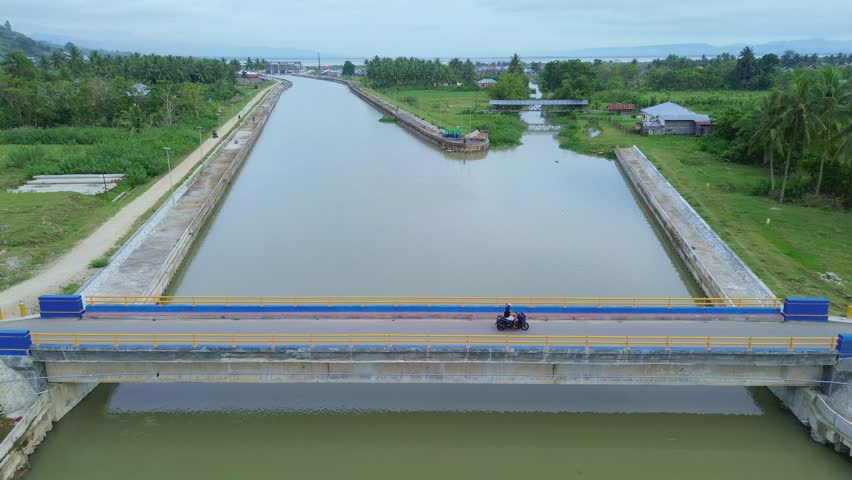 Cyclist on Bridge Over River Canal