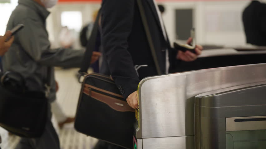 Crowd of People walking pass turnstile gate in subway station in rush hour morning. Passenger tap ic card or smartphone on auto gate making payment for public transportation at subway station in city