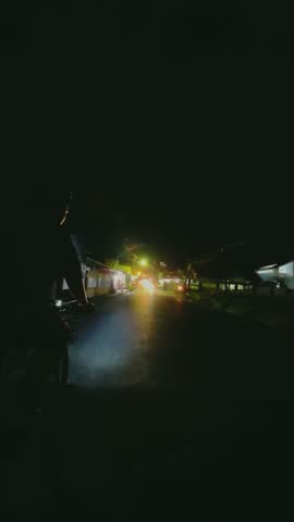 Man Riding Bicycle on City Street at Night