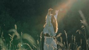Radiant golden sunlight bathing young woman in blue sweater, standing amid tall grass with arms raised, embodying nature's beauty and freedom - Powered by Shutterstock - Get 15% off with code: PIKWIZARD15