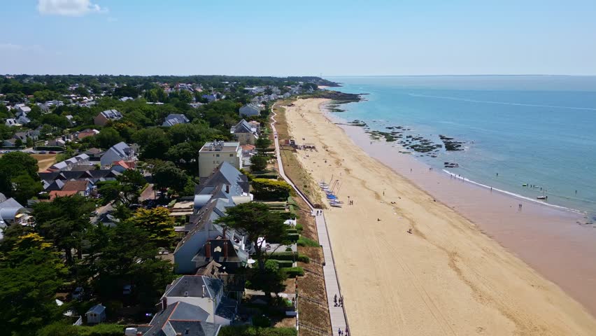 Amazing drone movement along the Plage de Bonne-Source beachside with residential homes and calm water, Pornichet, Loire-Atlantique, France.
