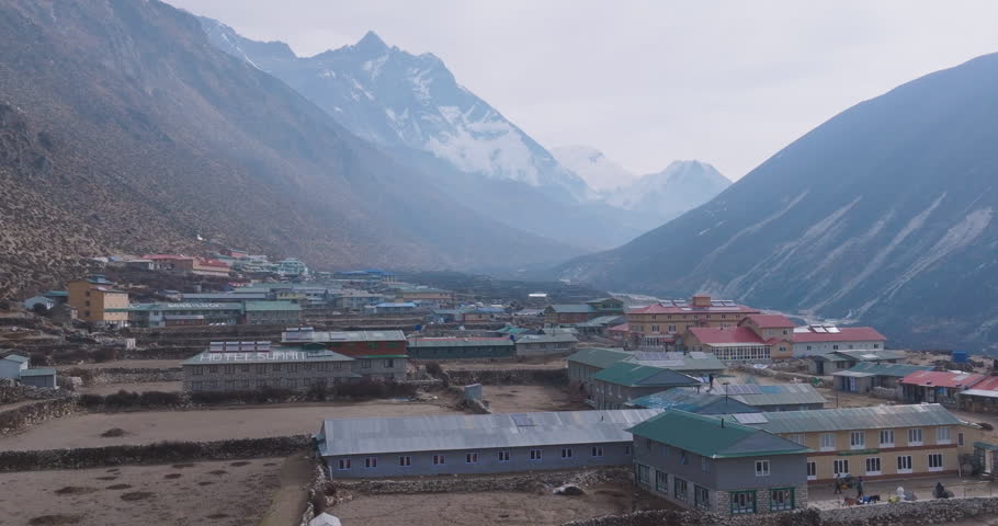 Aerial view of Dingboche Village (4400m) with colorful houses, mountain peaks, dry terrain, and unclear weather in Himalayas Nepal Travel and Tourism nature conservation alert