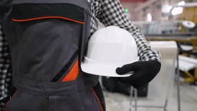 Engineer holding white hard hat in a factory - Powered by Shutterstock - Get 15% off with code: PIKWIZARD15