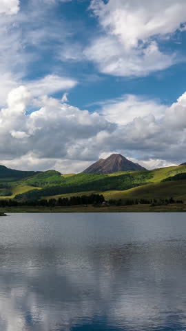 Vertical Hyperlapse, Clouds and Green Mountain Hills, Reflection on Alpine Lake