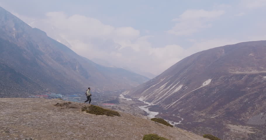 A tourist explores the Everest Base Camp route at Dingboche, Nepal. Stunning landscape views in cloudy Himalayan weather captured by drone, Nepali landscape in Himalayas travel and tourism