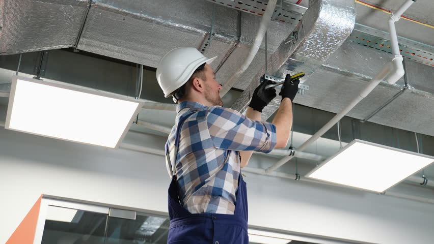 Hvac technician installing air duct system in building