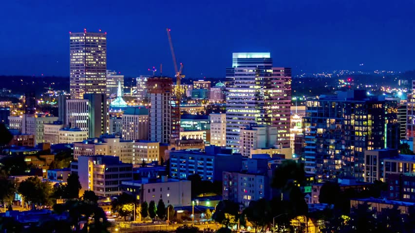 Nighttime cityscape of portland, oregon with illuminated buildings and a dark blue sky