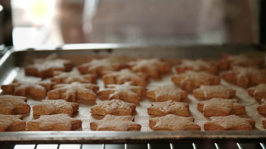 Baking snowflake and star shaped cookies in the oven for holiday celebration