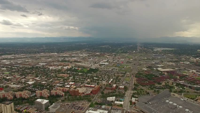 Aerial view of denver colorado cityscape with mountains and cloudy sky in background