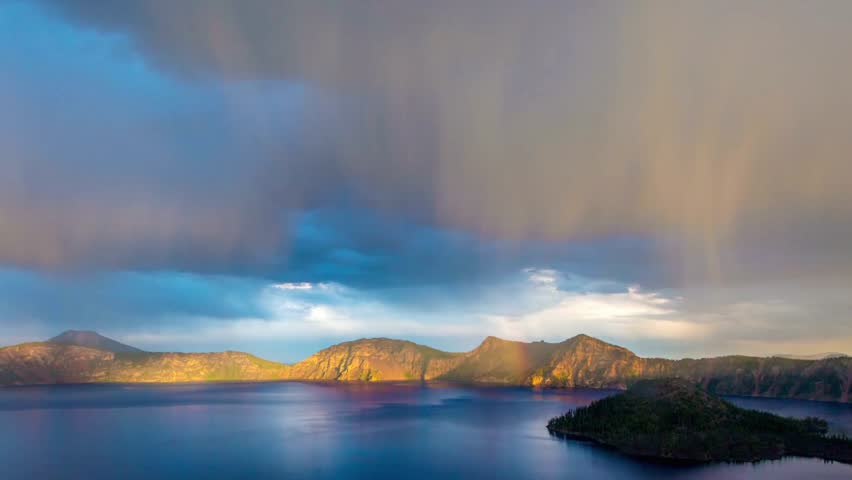 Panoramic view of crater lake national park with sunlight filtering through the clouds