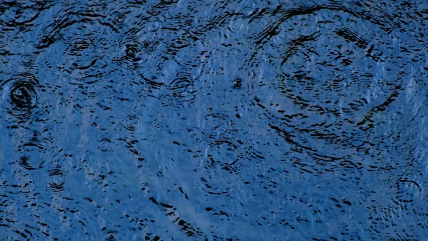 Slow motion water droplets falling into water. Close-Up of water droplets creating ripples. Water droplet mpact in slow motion.