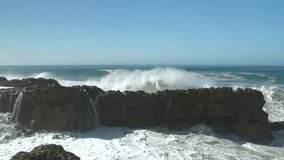 SLOW MOTION: Crashing of a big wave against dark shore rocks causes an immense explosion of white water and foam. Incredible power of the Atlantic Ocean creates dramatic scenes along Moroccan coast. - Powered by Shutterstock - Get 15% off with code: PIKWIZARD15