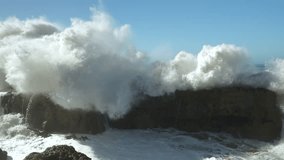 SLOW MOTION: Crashing of a big wave against dark shore rocks causes an immense explosion of white water and foam. Incredible power of the Atlantic Ocean creates dramatic scenes along Moroccan coast. - Powered by Shutterstock - Get 15% off with code: PIKWIZARD15