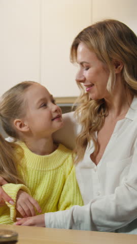 Caucasian family funny weekend at home kitchen happy childhood mother and daughter joyful smiling hold hands dancing to music singing moving dance mom with child girl hugging cuddling love childcare