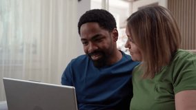 Diverse couple happily looking at laptop tracking personal savings and investment progress at home - Powered by Shutterstock - Get 15% off with code: PIKWIZARD15