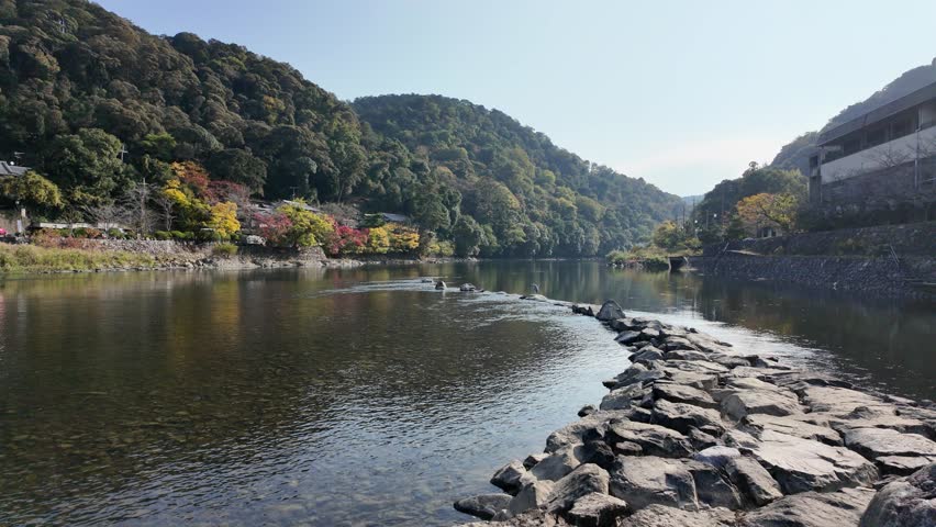 Scenic sight on a sunny autumn morning along the Uji river in Kyoto, Japan.