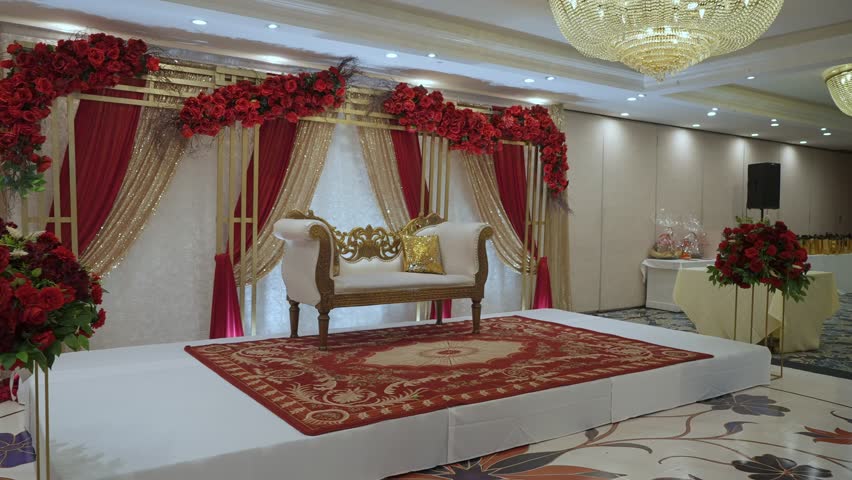The wedding stage decor is absolutely stunning, featuring glamorous floral arrangements in rich, vibrant colors