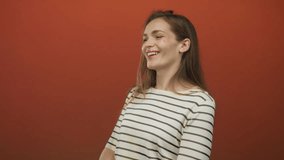 A young woman smiling with closed eyes, tilting her head and wearing a striped shirt in a studio; joy. - Powered by Shutterstock - Get 15% off with code: PIKWIZARD15