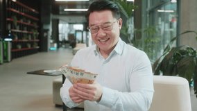 Happy mature businessman in formal shirt counting cash money euro banknotes and looking up, celebrate, success career, income, wealth at modern office lobby. Confident smile employee in eyeglasses. - Powered by Shutterstock - Get 15% off with code: PIKWIZARD15
