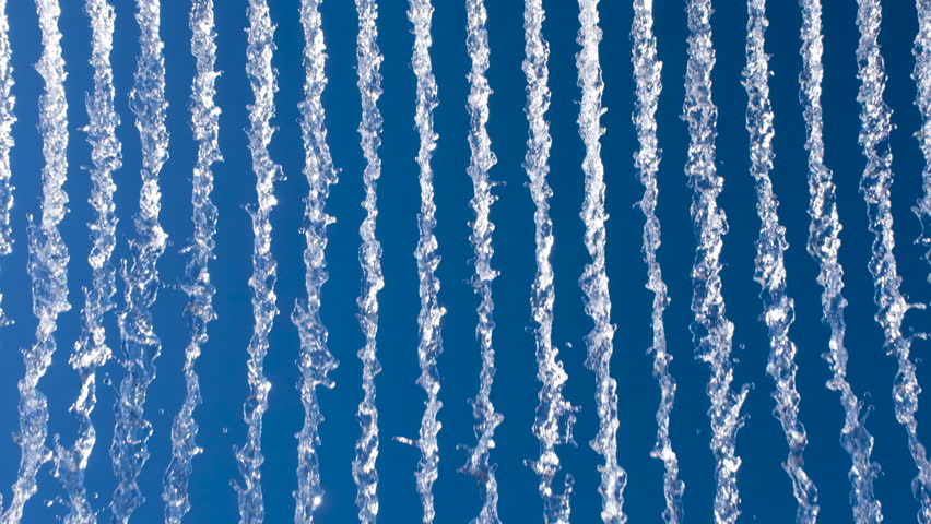 Vibrant display of water streams against a bright blue sky, creating a dynamic, abstract pattern ideal for nature or energy-themed visuals