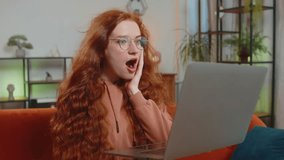 Surprised Caucasian redhead woman lady using laptop, receive mail good news message, wow shocked by sudden victory celebrate lottery jackpot win purchases online shopping at home on sofa. Lifestyles. - Powered by Shutterstock - Get 15% off with code: PIKWIZARD15
